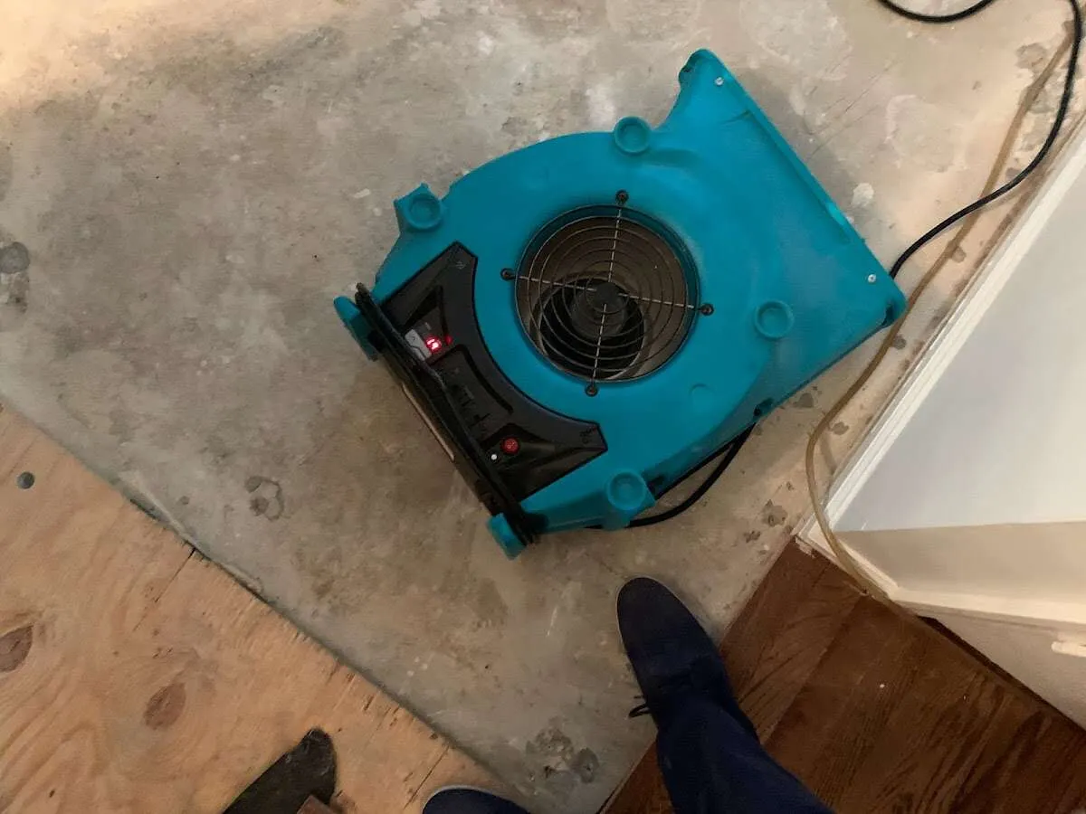 Air mover drying subfloor during Commercial Water Damage Restoration in Omak